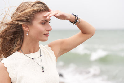 Model looking out the beach wearing Trollbeads bracelets, earrings and necklace